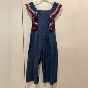 Free the Roses blue jean wide leg jumpsuit with red, white, and blue fringe.